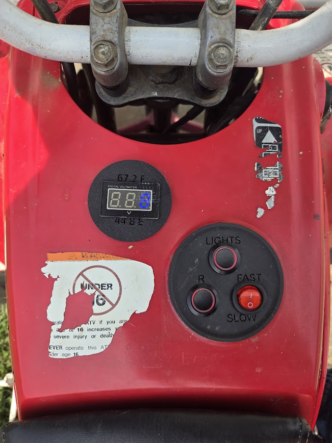 The ATV's control panel with switches and a voltage display